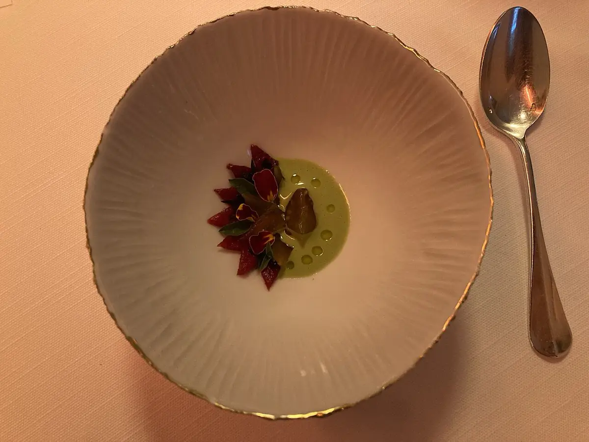 A plated tasting-menu course on a wide ceramic plate