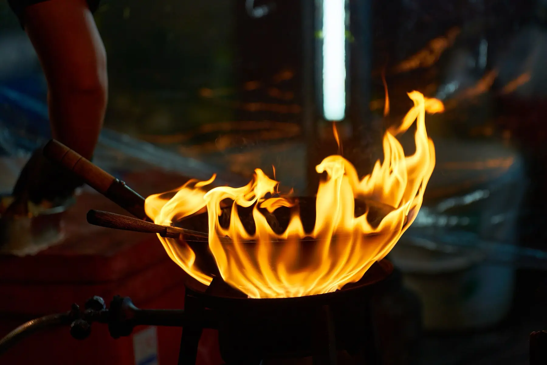 Flames rising from a wok at a street kitchen